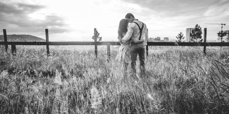 couple embracing in open field, men love your wife