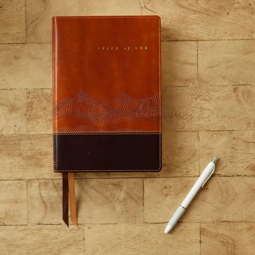 Peace of God Bible NKJV resting on a wooden table with pen, illustrating daily devotional use and Scripture reading focused on biblical peace.